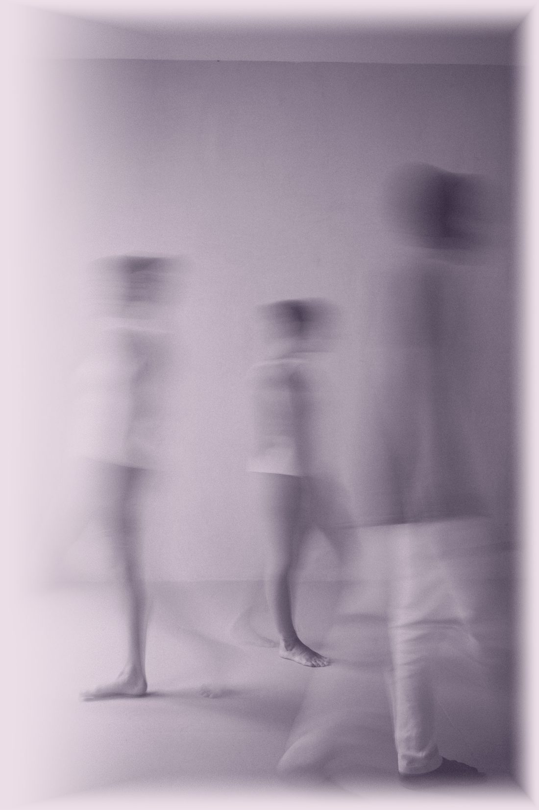 Three people walking through a pale room, blurred in motion