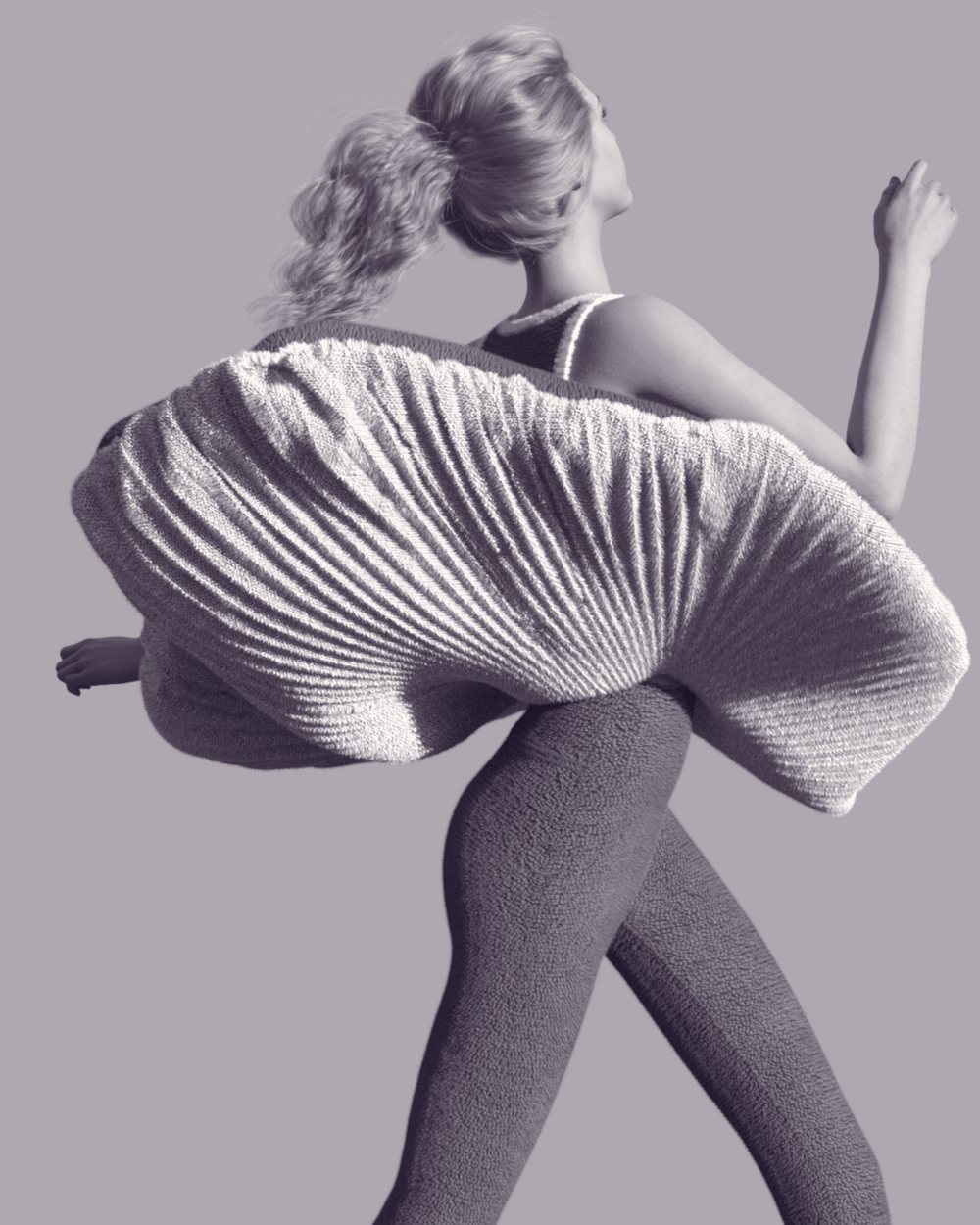 A woman mid-stride in a sculptural pleated skirt